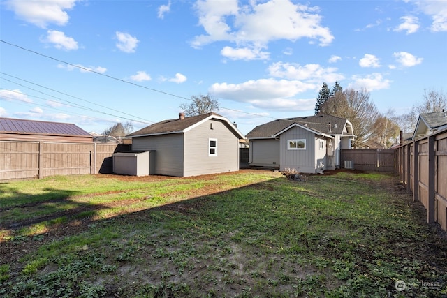 back of property featuring a yard and a shed