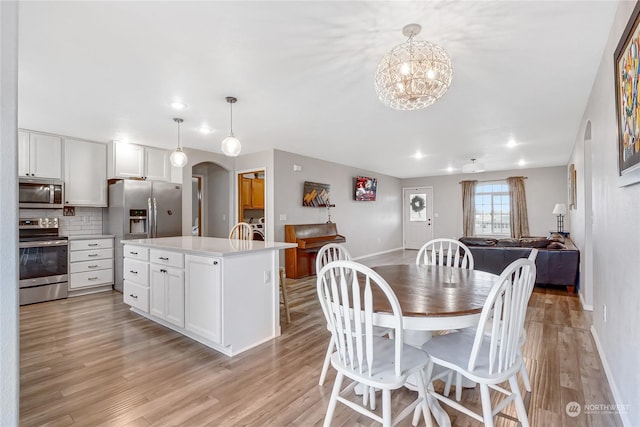 dining area featuring an inviting chandelier and light hardwood / wood-style flooring