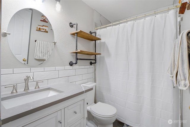 bathroom featuring toilet, vanity, and tasteful backsplash