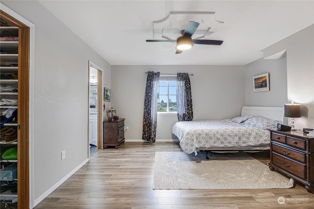 bedroom with ceiling fan, light hardwood / wood-style flooring, and ensuite bathroom