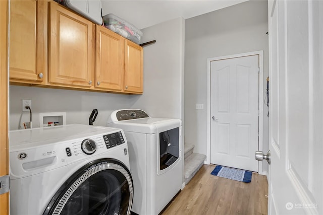 clothes washing area featuring washer and dryer, cabinets, and light hardwood / wood-style floors