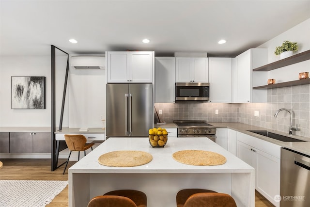 kitchen featuring sink, a wall mounted AC, a kitchen island, and high quality appliances