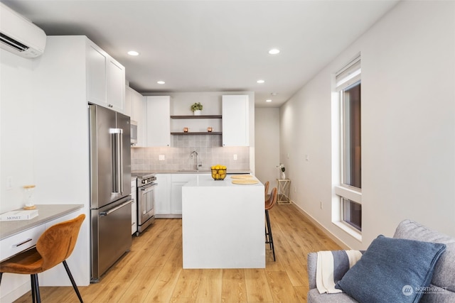 kitchen featuring white cabinetry, a center island, stainless steel appliances, and a breakfast bar area