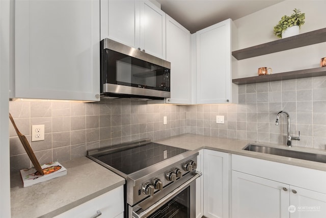 kitchen with white cabinets, stainless steel appliances, sink, and backsplash