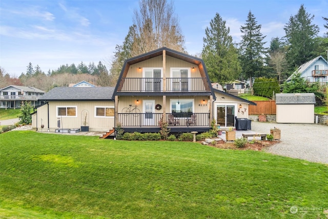 back of property with a patio, a yard, a storage shed, a balcony, and a deck