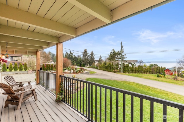 wooden terrace with covered porch and a yard