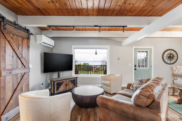 living room featuring a wealth of natural light, rail lighting, a barn door, a wall mounted air conditioner, and wood-type flooring