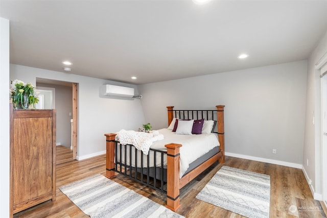 bedroom featuring an AC wall unit and hardwood / wood-style floors