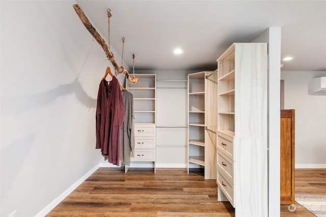 walk in closet with an AC wall unit and hardwood / wood-style floors