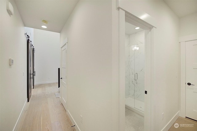 hall featuring light hardwood / wood-style floors and a barn door