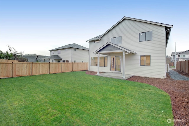 rear view of property featuring a lawn and a patio