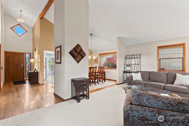 living room featuring high vaulted ceiling, wood-type flooring, a chandelier, and radiator heating unit