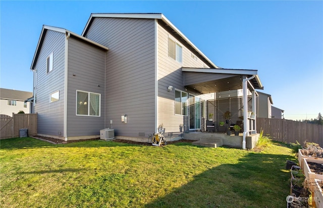 back of property featuring central AC and a yard