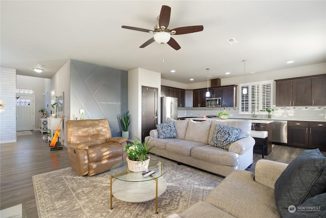 living room with dark hardwood / wood-style floors and ceiling fan