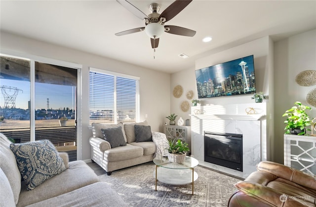 living room featuring ceiling fan, wood-type flooring, and a premium fireplace