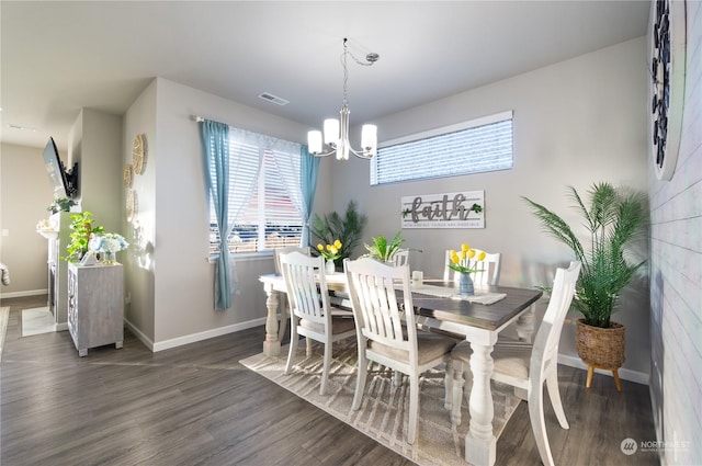 dining room featuring dark wood-type flooring and an inviting chandelier