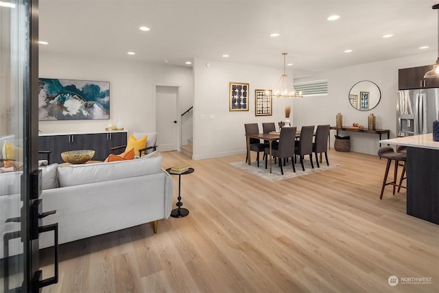 living room featuring light wood-type flooring and an inviting chandelier