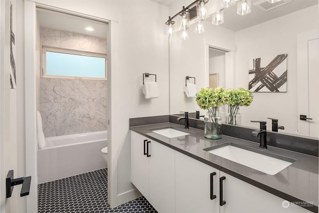 full bathroom featuring toilet, vanity, and tiled shower / bath combo