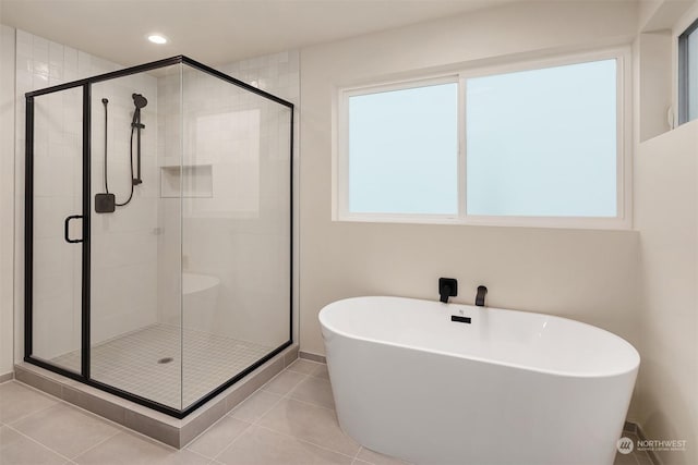 bathroom featuring plenty of natural light, tile patterned floors, and plus walk in shower