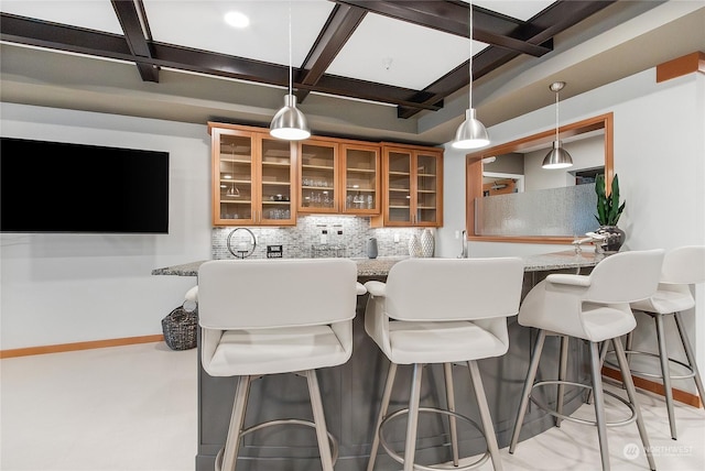 kitchen featuring light stone counters, coffered ceiling, decorative light fixtures, backsplash, and beamed ceiling