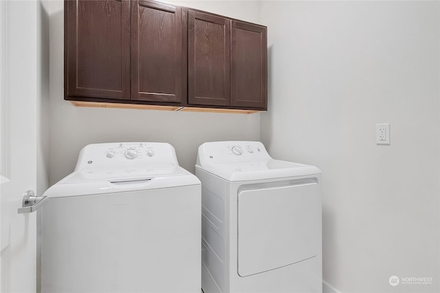 laundry room with washing machine and clothes dryer and cabinets