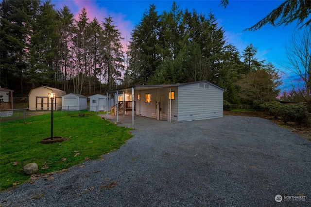 view of front of property featuring a storage shed and a lawn