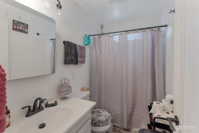 bathroom featuring toilet, vanity, and curtained shower