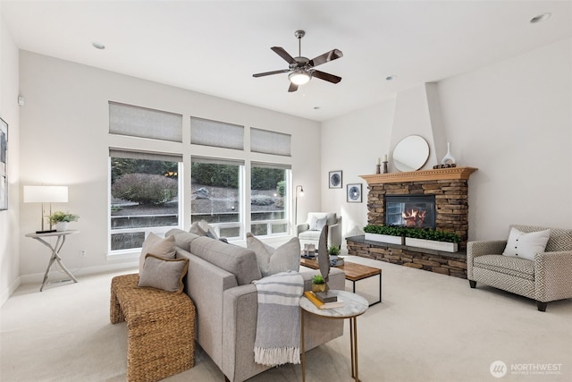 living area featuring carpet, a fireplace, and a ceiling fan