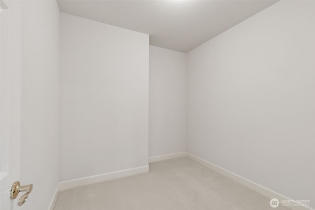 empty room featuring baseboards and light colored carpet