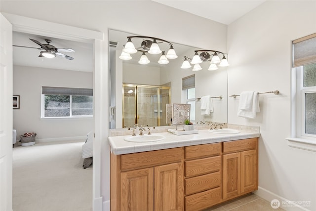 full bathroom with a sink, a shower stall, baseboards, and double vanity