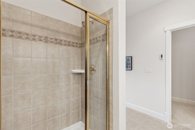 full bathroom with a stall shower, baseboards, and tile patterned floors