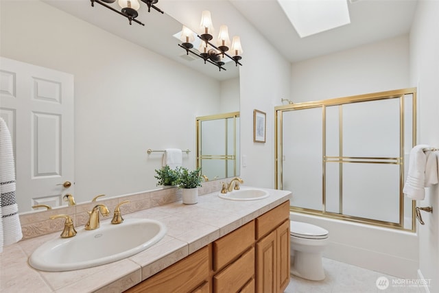 full bathroom with a skylight, enclosed tub / shower combo, a sink, and double vanity