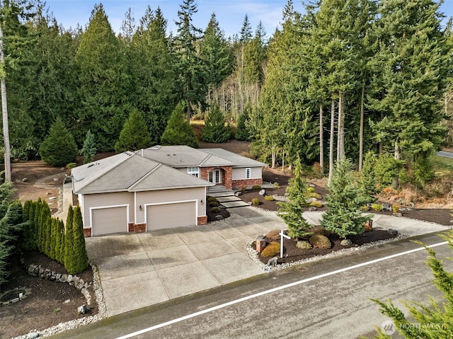 ranch-style home with driveway, brick siding, and an attached garage