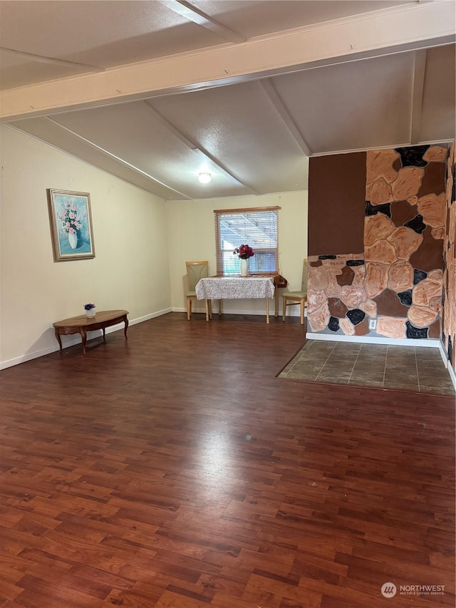 unfurnished room featuring vaulted ceiling with beams and dark wood-type flooring