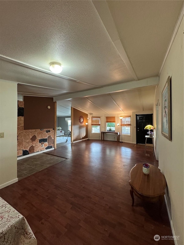 living room featuring a textured ceiling, vaulted ceiling, dark hardwood / wood-style floors, and a fireplace