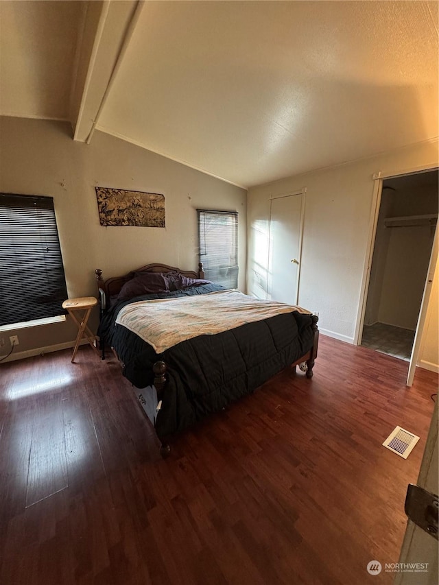 bedroom with lofted ceiling with beams and wood-type flooring