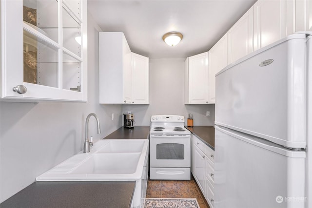 kitchen with sink, white appliances, and white cabinetry