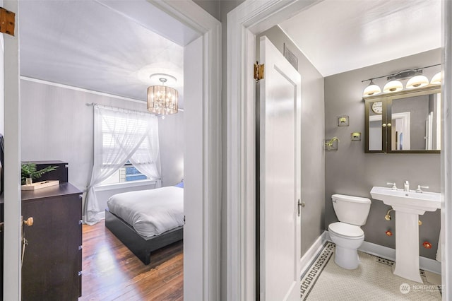 bathroom with sink, a notable chandelier, hardwood / wood-style floors, toilet, and crown molding