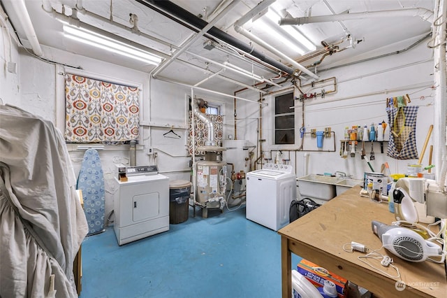 basement featuring sink, washing machine and dryer, and water heater