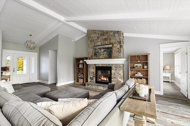 living room featuring wood-type flooring, vaulted ceiling with beams, and a fireplace