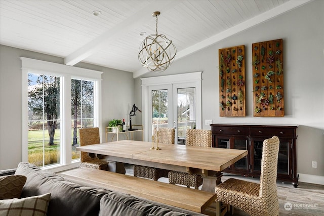 dining area featuring a healthy amount of sunlight, light wood-type flooring, a notable chandelier, and vaulted ceiling with beams