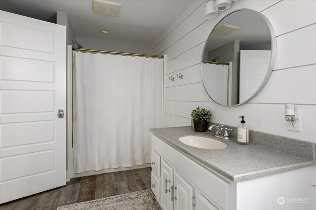 bathroom featuring vanity, a shower with curtain, wood walls, and hardwood / wood-style flooring