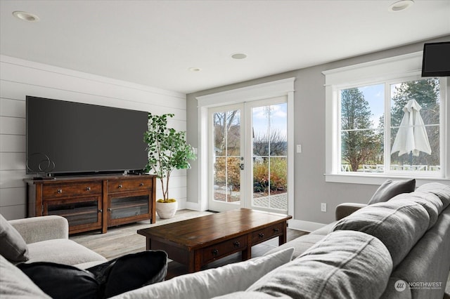 living room with light wood-type flooring and wood walls