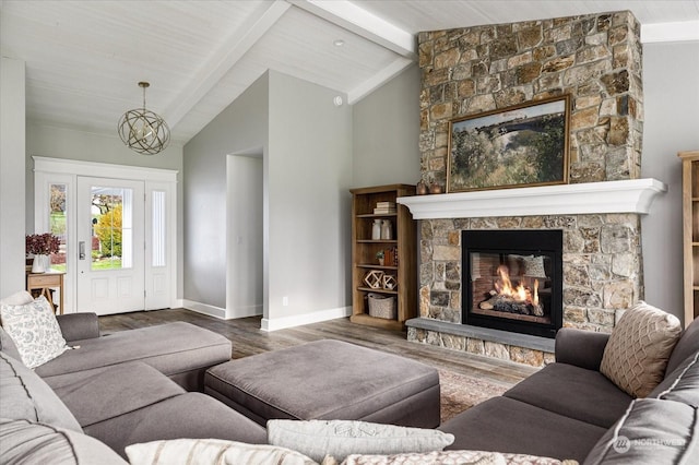 living room with beam ceiling, an inviting chandelier, hardwood / wood-style flooring, a stone fireplace, and high vaulted ceiling