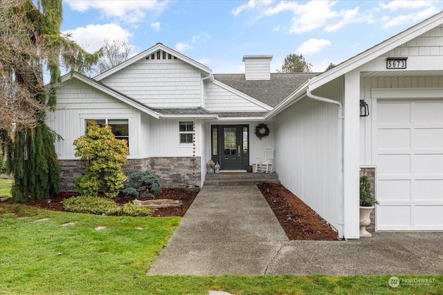 entrance to property with a garage and a yard