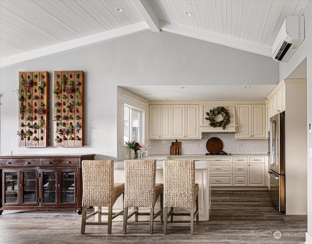 kitchen with premium range hood, tasteful backsplash, high end refrigerator, a kitchen breakfast bar, and vaulted ceiling with beams