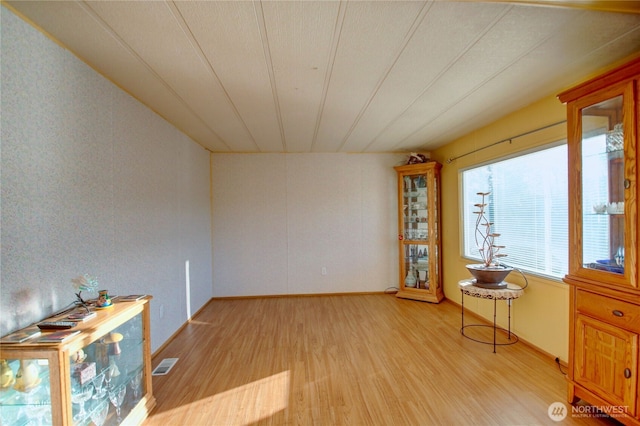 unfurnished room with light wood-style flooring and visible vents