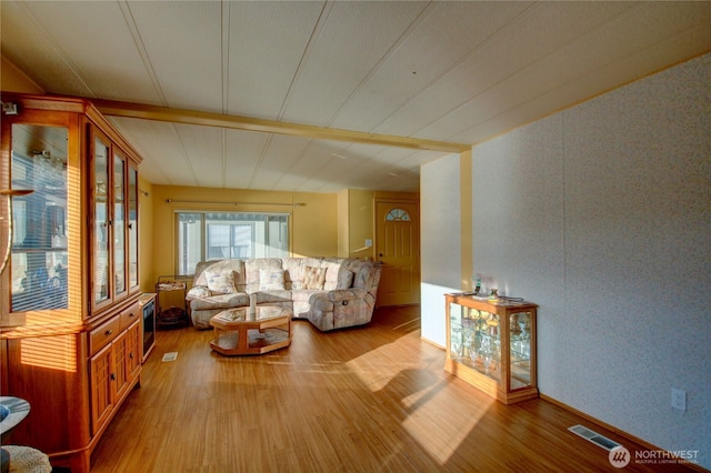 living area featuring visible vents and wood finished floors