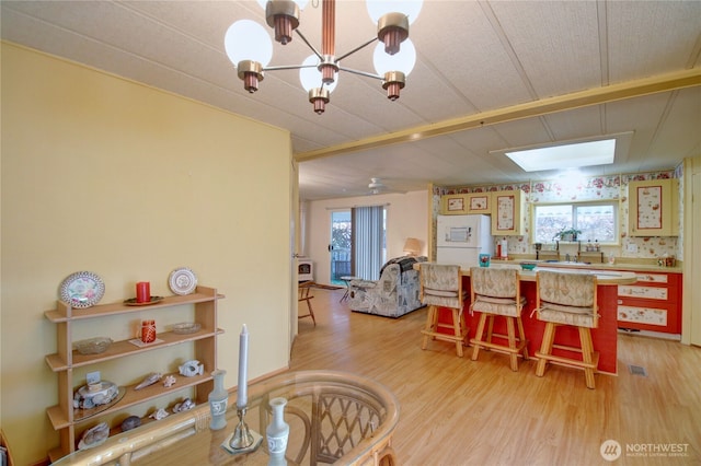 dining area featuring a chandelier and light wood-style flooring