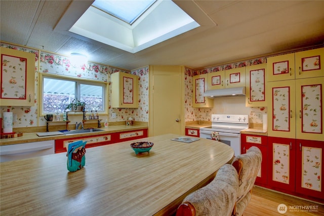 interior space with white appliances, under cabinet range hood, light countertops, and wallpapered walls